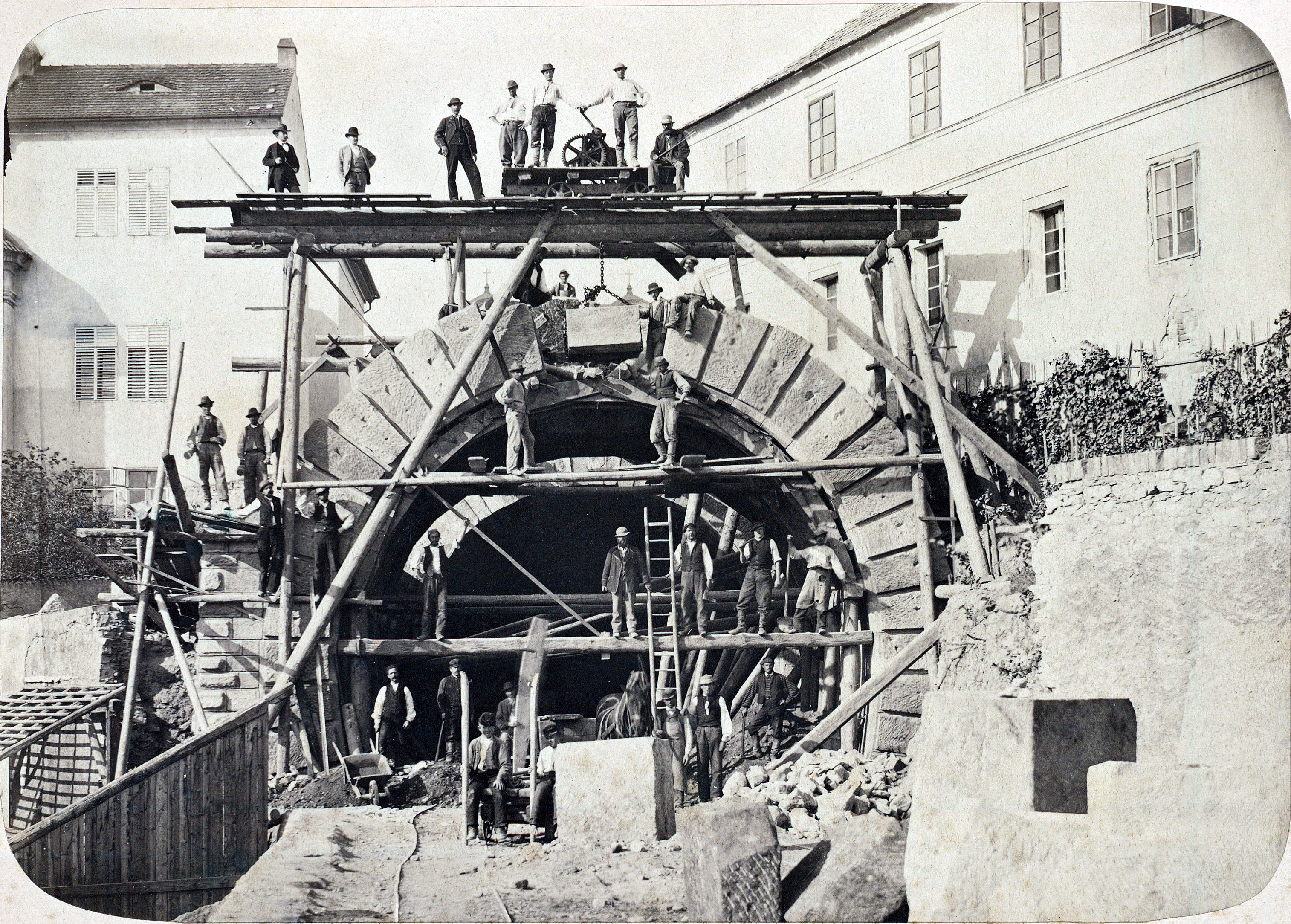 Historische foto van een team dat een stenen boog bouwt op een steiger