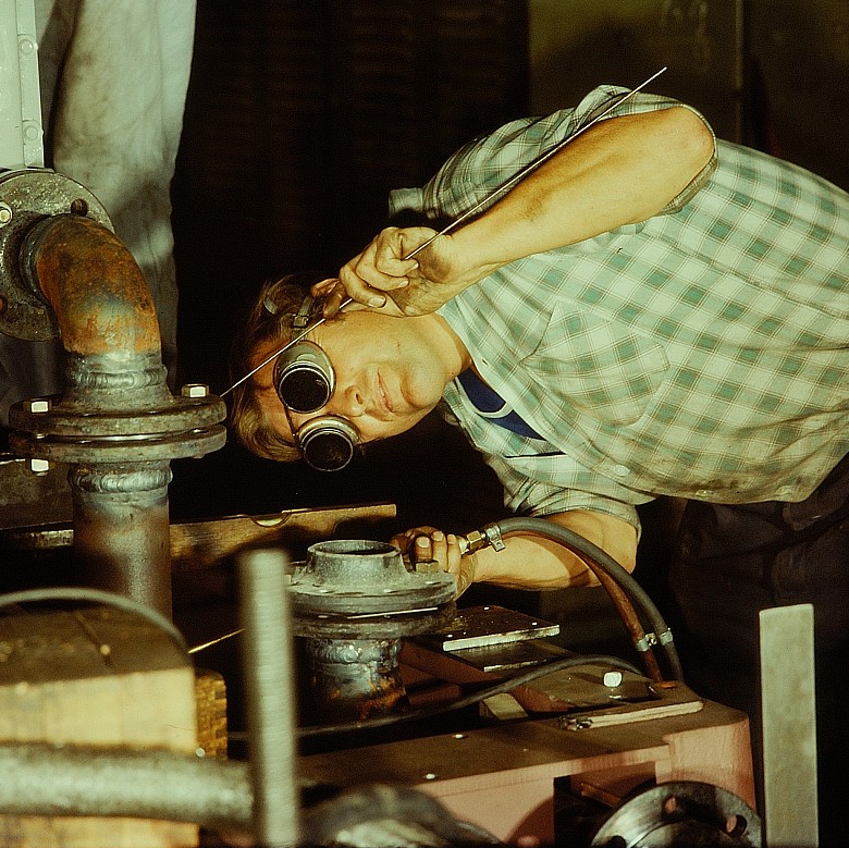 Een vakman voert precisiewerk uit aan een metalen installatie